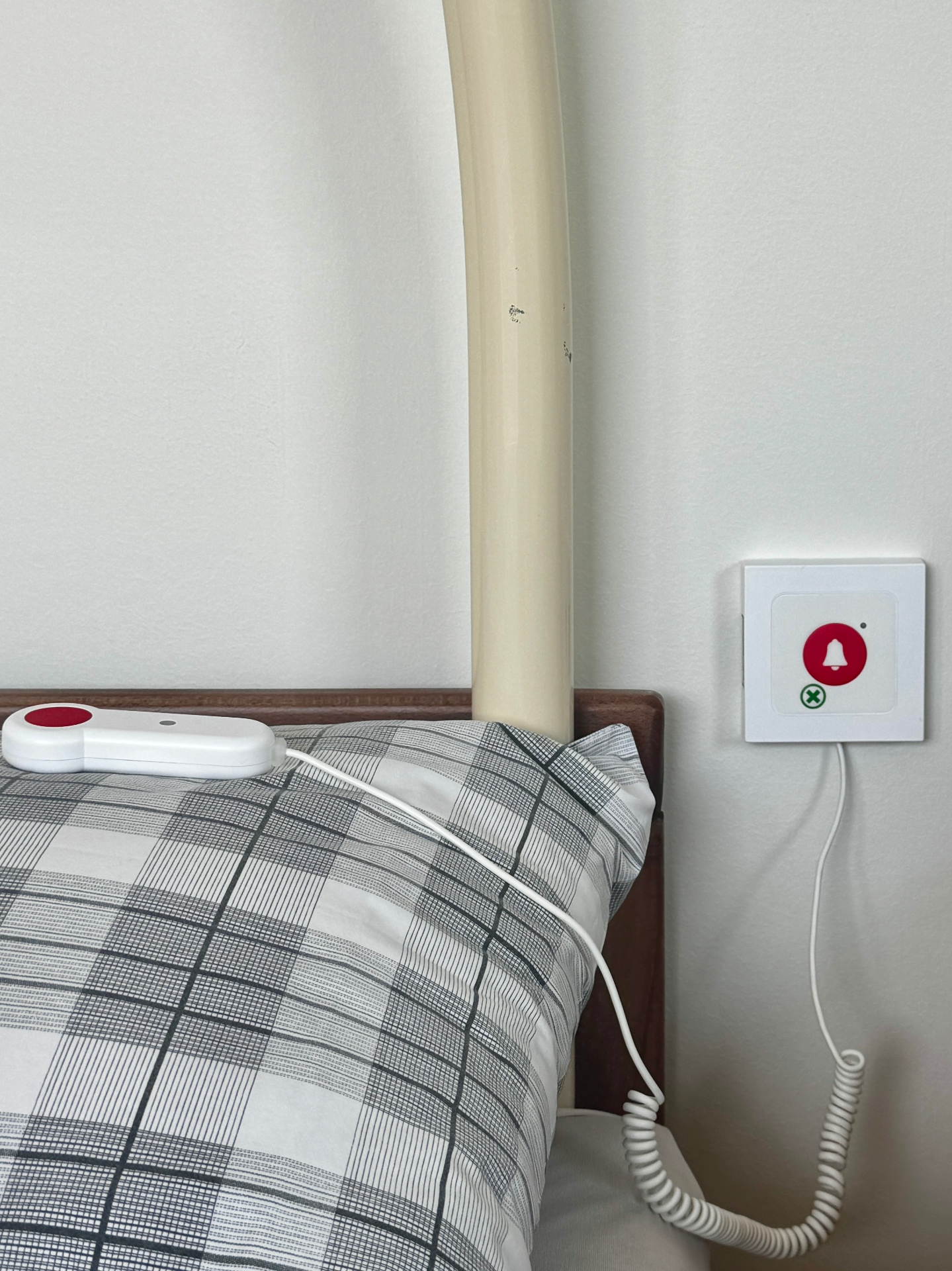 Bouton d'appel infirmière installé au chevet du patient avec poire d'appel filaire